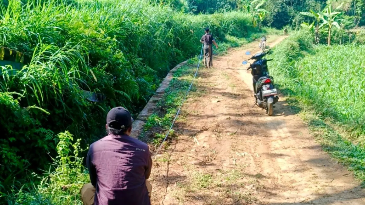 BAKAL DIBANGUN: Perangkat Desa Tambelang mengukur Jalan Dusun Laok Songai yang akan dibangun tahun ini. (Pemdes Tambelang For Jawa Pos Radar Bromo)