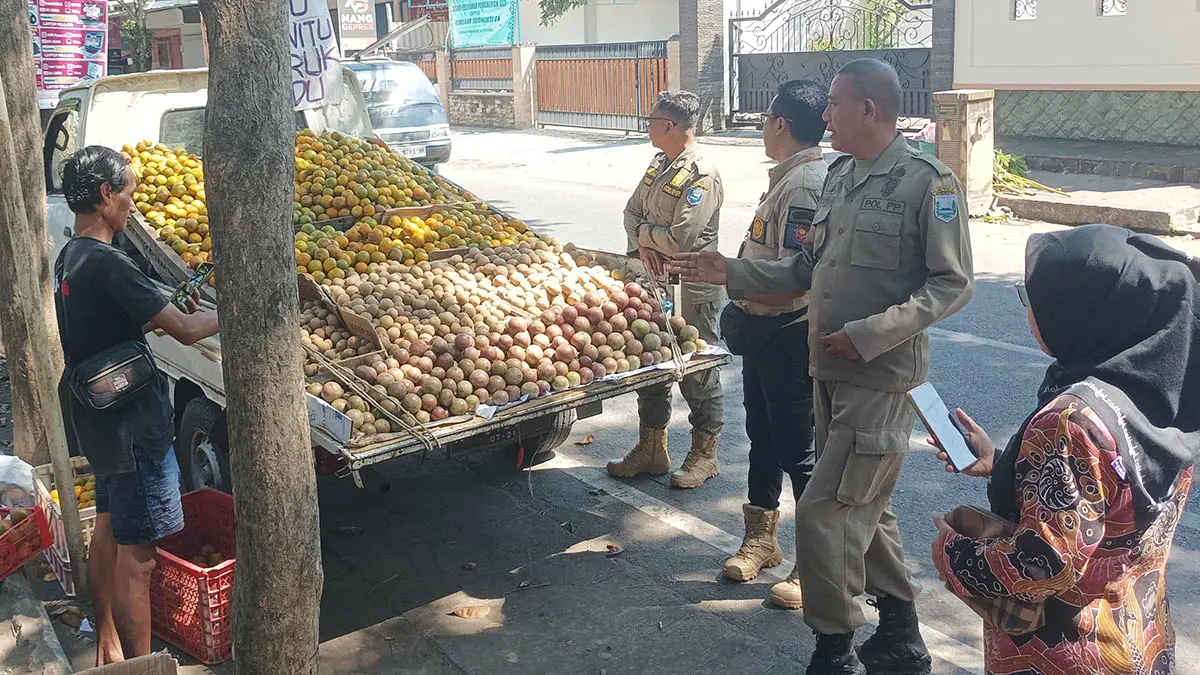 PERSUASIF: Salah satu pedagang yang berjualan di depan SMAN 1 Kraksaan yang ditertibkan personel Satpol PP. (Foto: Agus Faiz Musleh/Jawa Pos Radar Bromo)