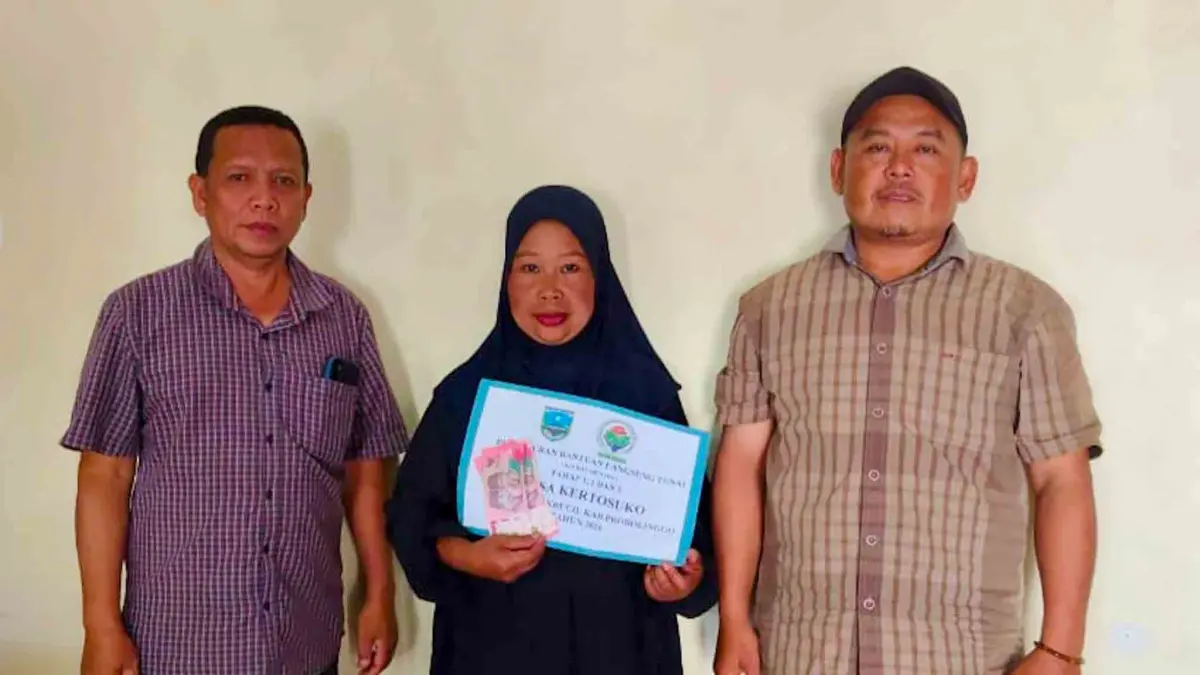 SALURKAN&nbsp;BANTUAN: Kepala Desa Kertosuko Sudarman (kiri) menyalurkan BLT-DD kepada keluarga penerima manfaat. (Pemdes Kertosuko For Jawa Pos Radar Bromo)