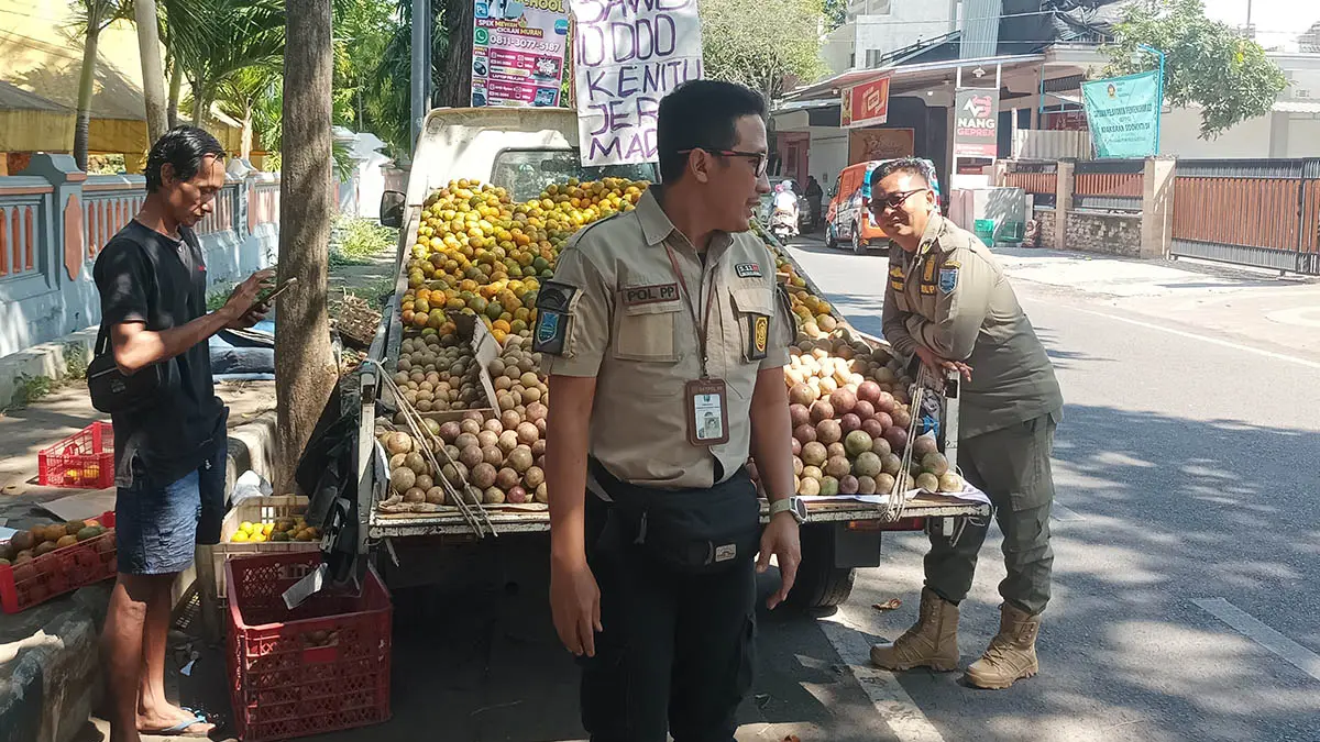 DITERTIBKAN: Salah satu pedagang yang berjualan di depan SMAN 1 Kraksaan saat ditertibkan personel Satpol PP beberapa waktu lalu. (Foto: Agus Faiz Musleh/Jawa Pos Radar Bromo)