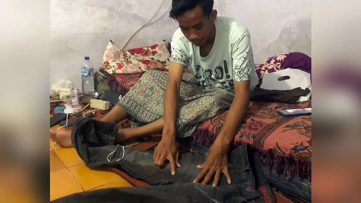 LUKA: Korban Muhammad Toni, 23 saat menunjukkan celana panjangnya yang penuh noda darah di rumahnya di Kelurahan/Kecamatan Mayangan, Minggu (19/7). (Inneke Agustin/ Radar Bromo)