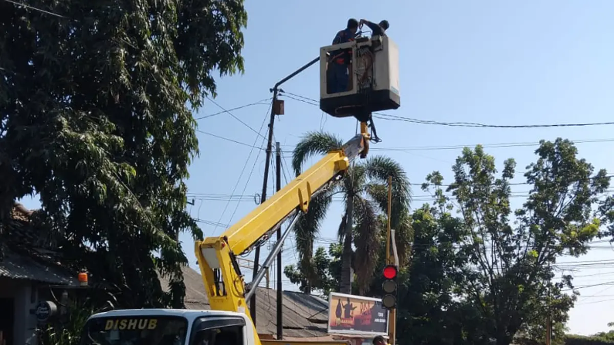PADAM: Pegawai Dishub Kota Probolinggo memperbaiki salah satu PJU di ruas jalan Kota Probolingo, Jumat (17/7). (DISHUB KOTA PROBOLINGGO for JAWA POS RADAR BROMO)