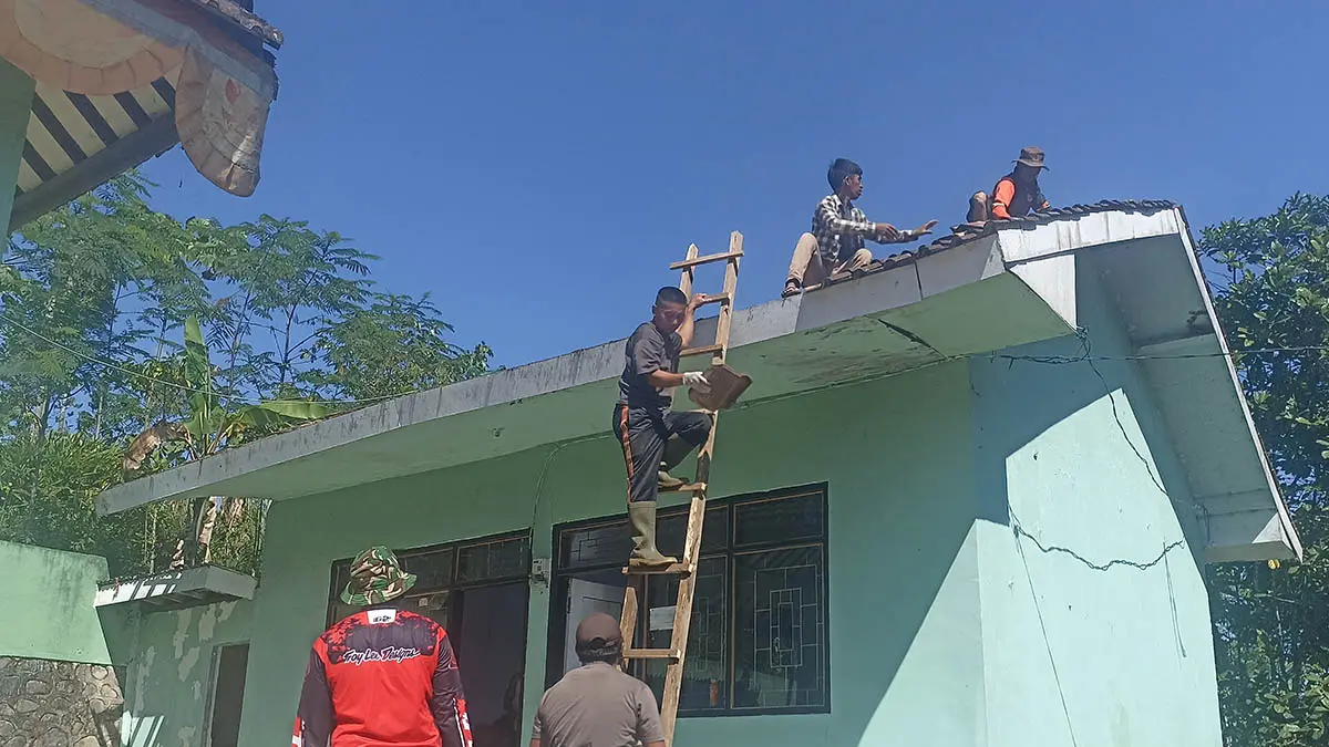 RENOVASI: Warga menurunkan genteng kantor desa, Kamis (16/7). Kantor desa ini di rehab untuk meningkatkan kenyamanan pelayanan kepada warga. (Foto: Jamaluddin/Jawa Pos Radar Bromo)