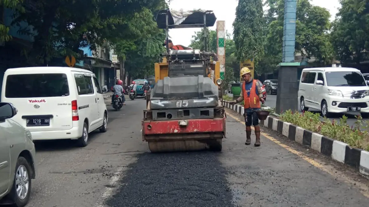 RUAS PANTURA: Pekerja memperbaiki jalan nasional di daerah Kecamatan Kraksaan. (Foto: Agus Faiz Musleh/Jawa Pos Radar Bromo)