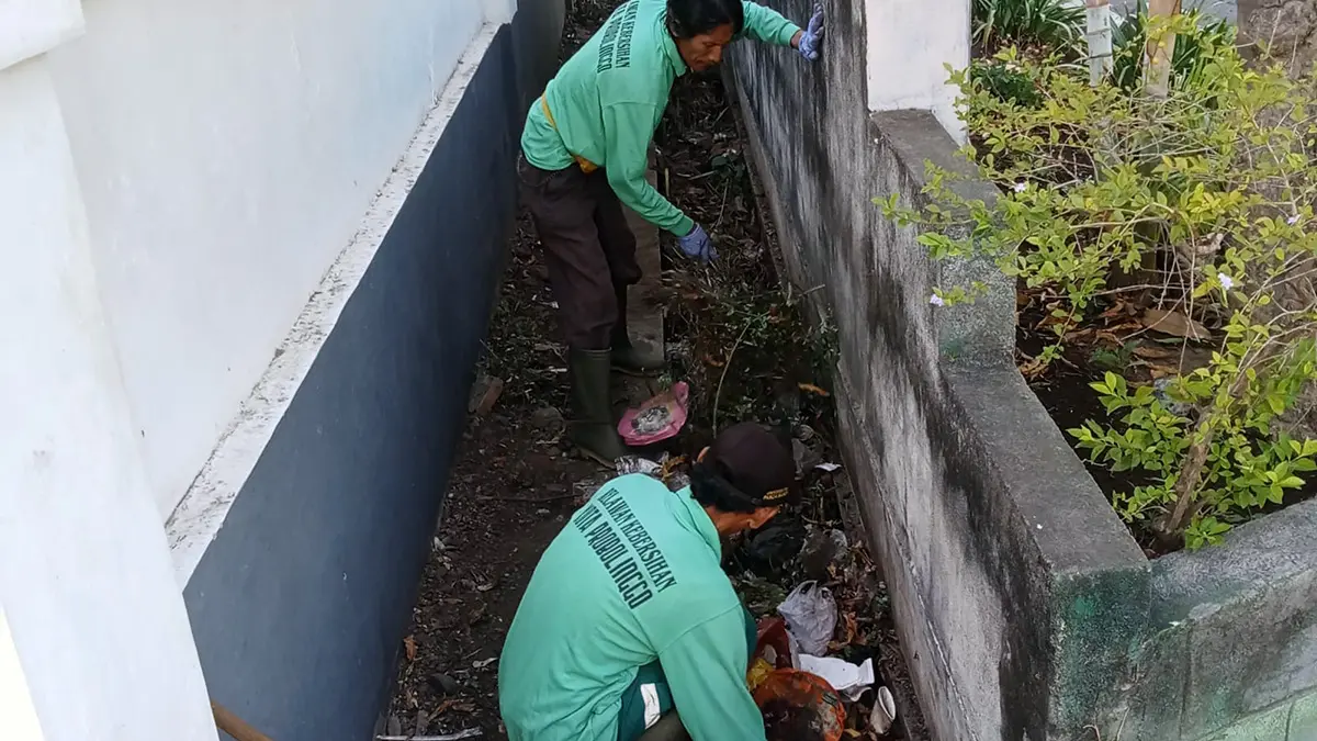 BERSIH-BERSIH: Petugas membersihkan saluran jalan Kaca Piring, kawasan Stadion Bayuangga dari sejumlah sampah.  