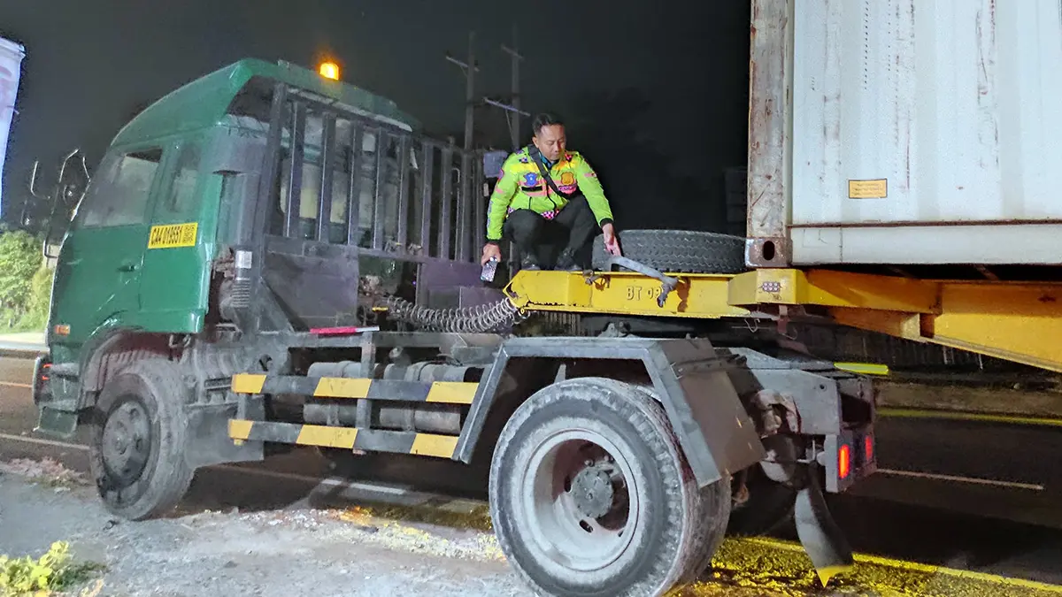 DIAMANKAN: Petugas mengamankan truk kontainer yang ban serepnya lepas hingga menimpa pemotor. 