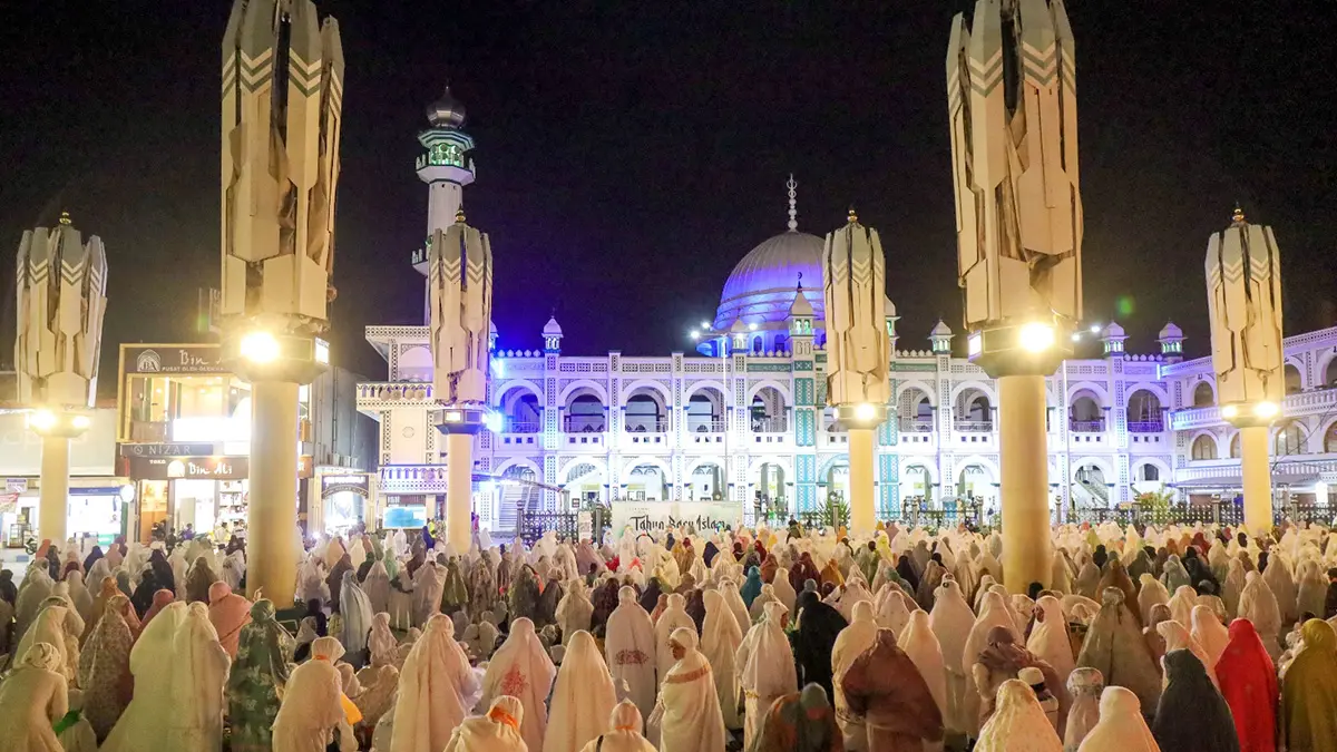 TAHUNAN: Ratusan jemaah dari luar kota istirahat di kawasan Payung Madinah setelah ziarah ke Makam Kiai Hamid Pasuruan. Agenda ini dilakukan setiap tahun sebelum melanjutkan perjalanan ke kawasan religi lainnya. (Mokhamad Zubaidillah/ Radar Bromo)