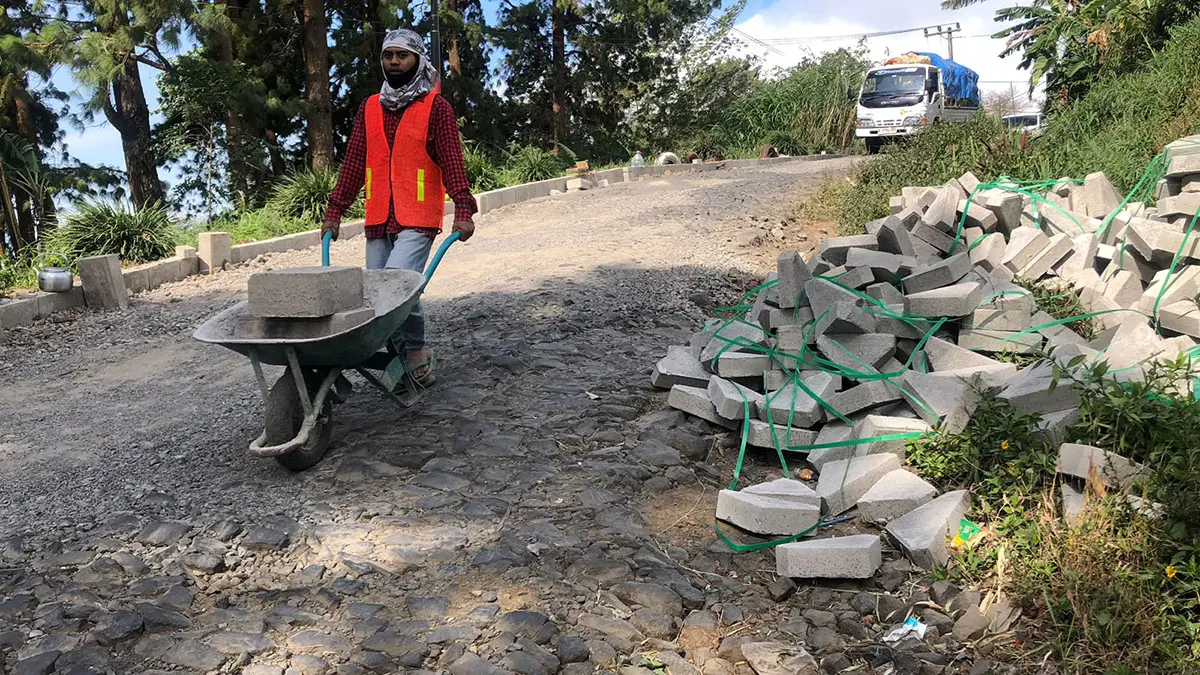 MULAI DIPERBAIKI: Seorang pekerja Dinas PUPR Kabupaten Probolinggo sedang memperbaiki jalan kabupaten di ruas Sumber-Ledokombo, Dusun Tempuran, Desa/Kecamatan Sumber, Kabupaten Probolinggo, Jumat (24/7). (Inneke Agustin/ Radar Bromo)