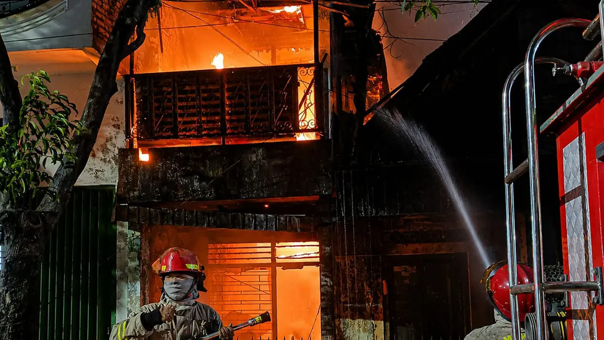 SEMPROT: Tim Damkar Satpol PP Kota Probolinggo berusaha memadamkan api di sebuah rumah kosong di Jalan Panjaitan, Kelurahan Sukabumi, Kecamatan Mayangan, Sabtu (25/7) dini hari.