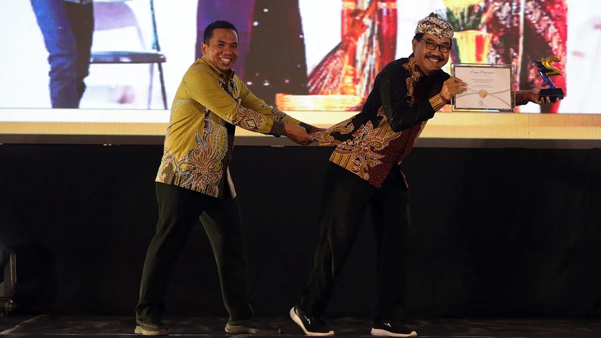 Agus Lithanta (kanan) saat menerima penghargaan Radar Bromo Awards 2026 kategori tokoh inspiratif dari direktur Jawa Pos Radar Bromo HA Suyuti. (Mokhamad Zubaidillah/ Radar Bromo)