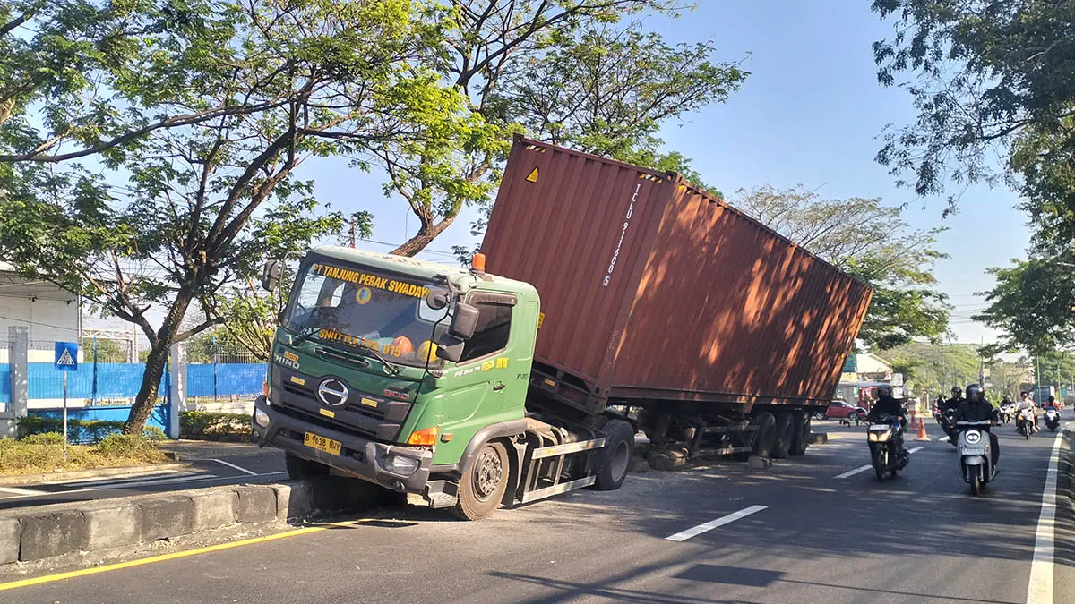 APES: Kontainer yang tabrak median hingga naik pembatas di jalan nasional ruas Surabaya - Malang, Desa Suwayuwo, Kecamatan Sukorejo. (Foto: Rizal F Syatori/Jawa Pos Radar Bromo)