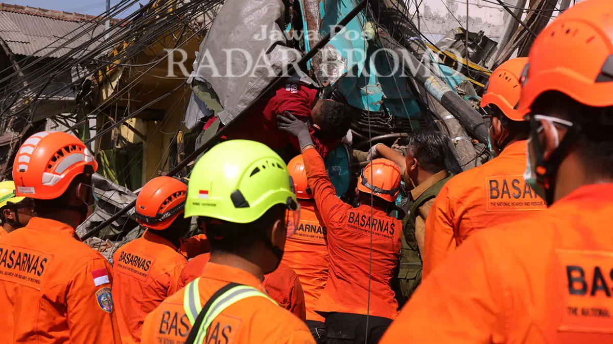 MASIH PEGANG KEMUDI: Tim Basarnas saat mengevakuasi jenazah sopir truk trailer warga Pakis, Malang yang memicu tabrakan karambol hingga merenggut 4 korban jiwa di jalan raya Ngerong, Gempol, Kabupaten Pasuruan. (Mokhamad Zubaidillah/ Radar Bromo)