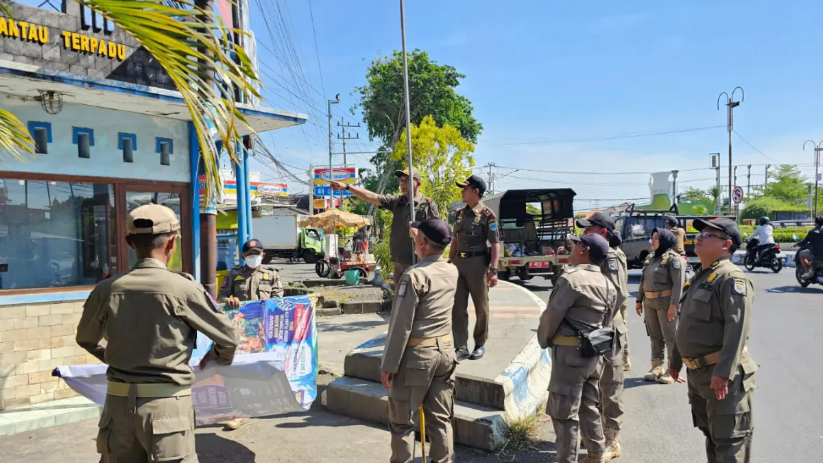 COPOT: Sejumlah Anggota Satpol PP Kota Probolinggo menertibkan reklame di salah satu ruas jalan kota, Senin (27/7). (SATPOL PP KOTA PROBOLINGGO FOR JAWA POS RADAR BROMO)