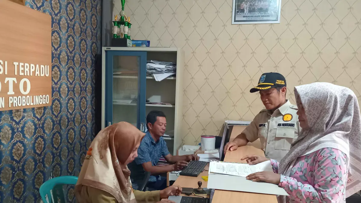 MAKIN MUDAH: Pj Kepala Desa Boto Saiful mendampingi warga mengurus dokumen kependudukan. (DIDIK PURWANTO/JAWA POS RADAR BROMO.)