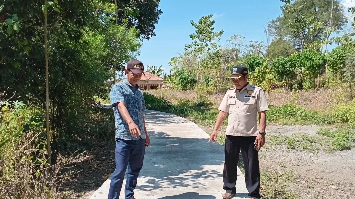 MULUS: Pj Kepala Desa Boto Saiful bersama Kasi Pembangunan Sitam menunjukkan hasil pembangunan jalan rabat beton Dusun Krajan RT 7/RW 3.