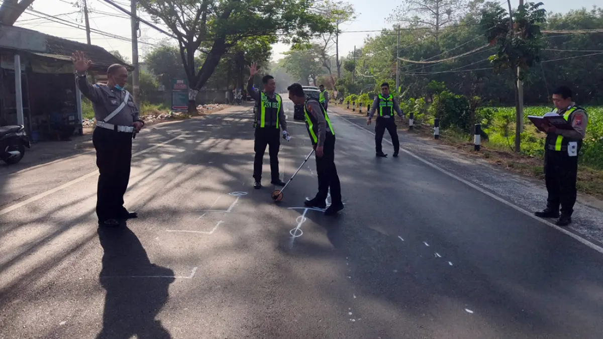 SELIDIKI PENYEBAB: Anggota Satlantas Polres Pasuruan mengumpulkan data dan mendokumentasikan titik benturan pasca kecelakaan tragis di dekat gapura Desa Kurung, Kejayan. Polisi masih mendalami kelalaian pengendara dalam insiden yang menewaskan Siti Amnah, 27.
