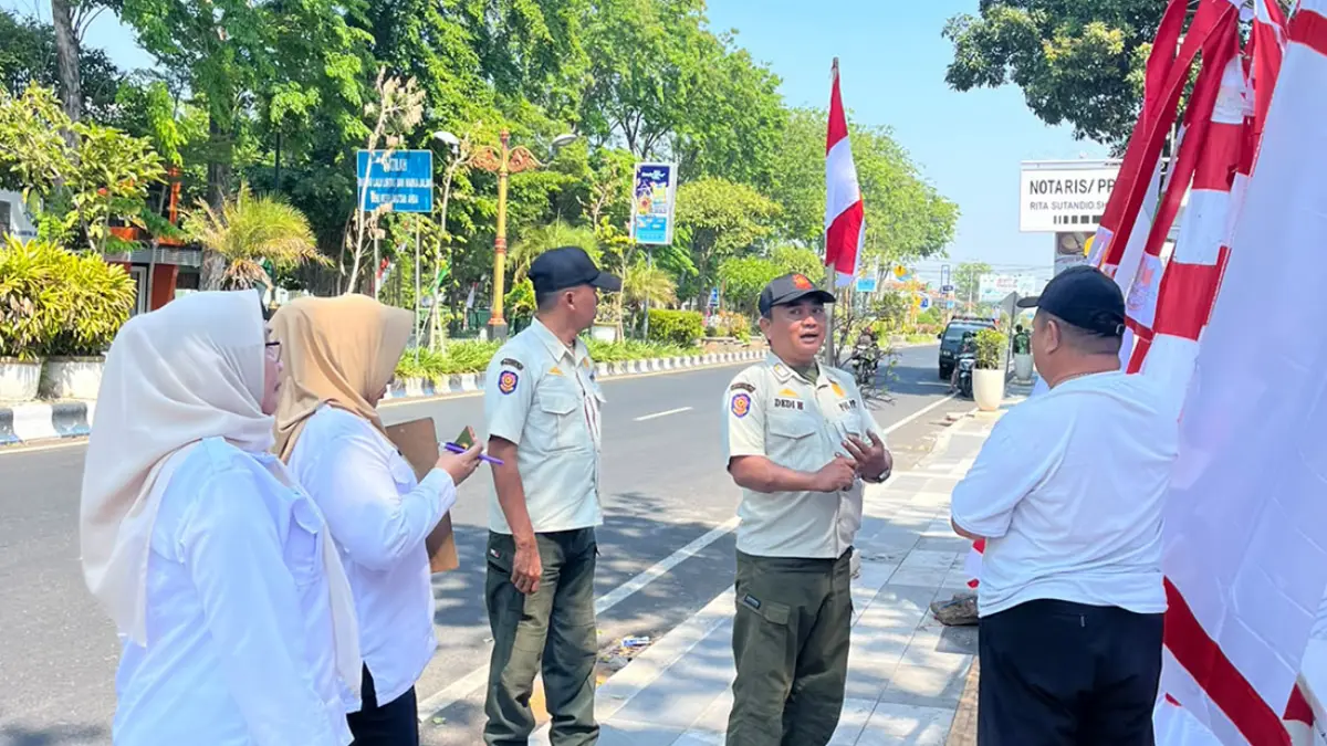 DITERTIBKAN: Petugas Satpol PP Kota Probolinggo saat menghalau satu edagang umbul-umbul yang nekat berjualan di trotoar Jalan Panglima Soedirman, Kota Probolinggo, Rabu (29/7) siang. 