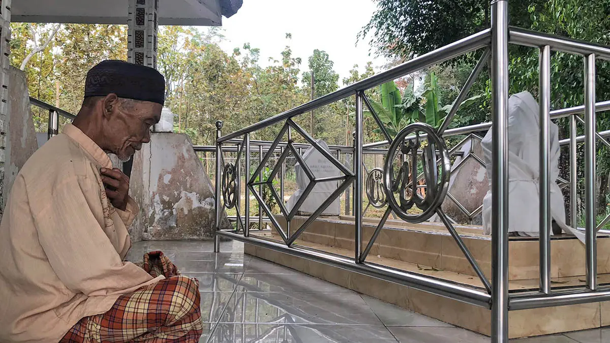 BERDOA: Juru Kunci Makam Mbah Mataram, Terus saat berdoa di Makam Mbah Mataram, Desa Lambangkuning, Kecamatan Lumbang, Kabupaten Probolinggo. (Inneke Agustin/Radar Bromo)