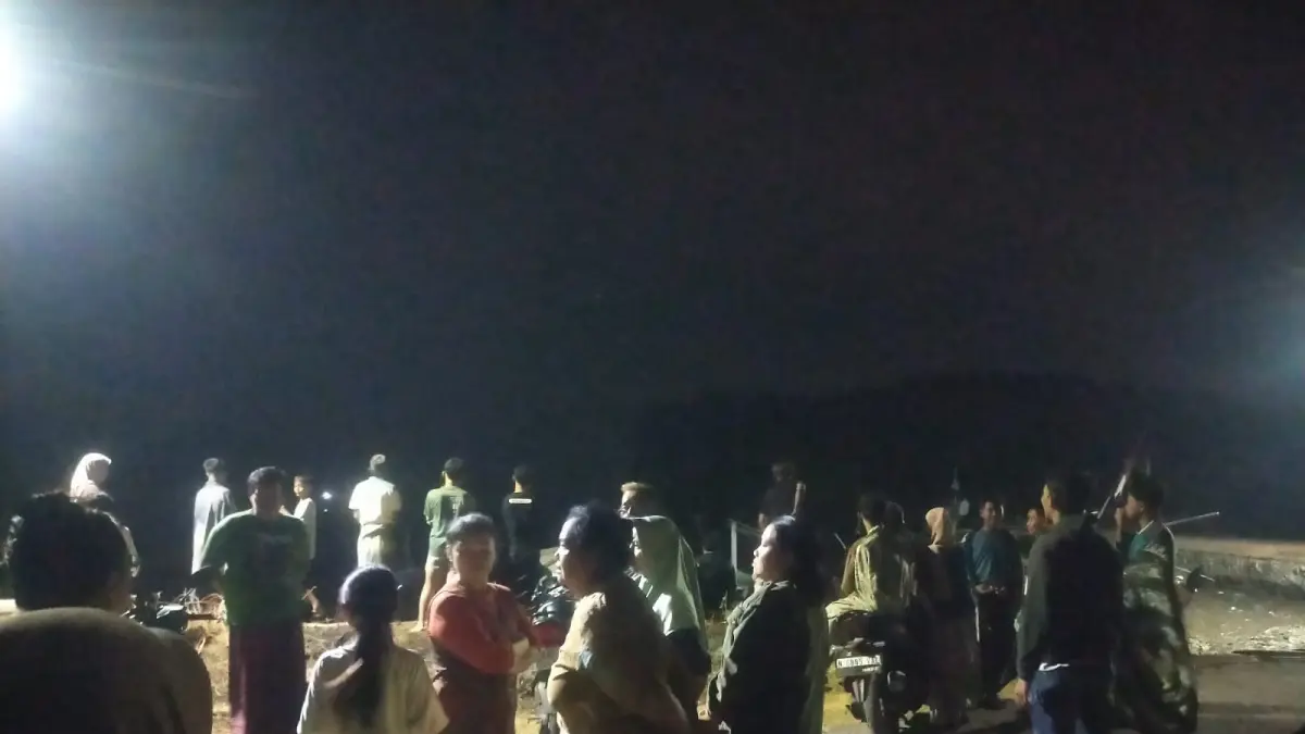 MENUNGGU: Warga Penunggul di Nguling di tepi pantai menunggu proses pencarian Sugianto. (Foto: Polres Pasuruan Kota for Jawa Pos Radar Bromo)