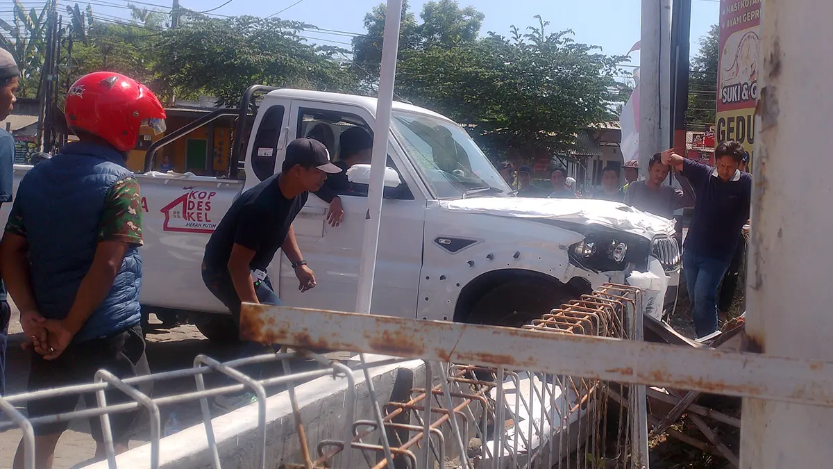 TABRAK PAGAR: Pikap Scorpio Mahindra 4x4 Nopol B 9315 XUY yang bertuliskan Kopdes Merah Putih berhenti setelah menabrak pagar tembok milik Alfamart di Nguling. (Istimewa)