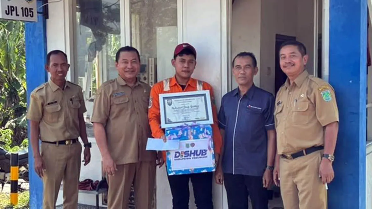 APRESIASI: Kepala Dinas Perhubungan Kabupaten Pasuruan Digdo Sutjahjo saat memberikan apresiasi kepada Muhammad Shofi Bahtiar, 24, penjaga pintu perlintasan kereta api (PJL) JPL 105 Bangil. (Dishub Kabupaten Pasuruan)
