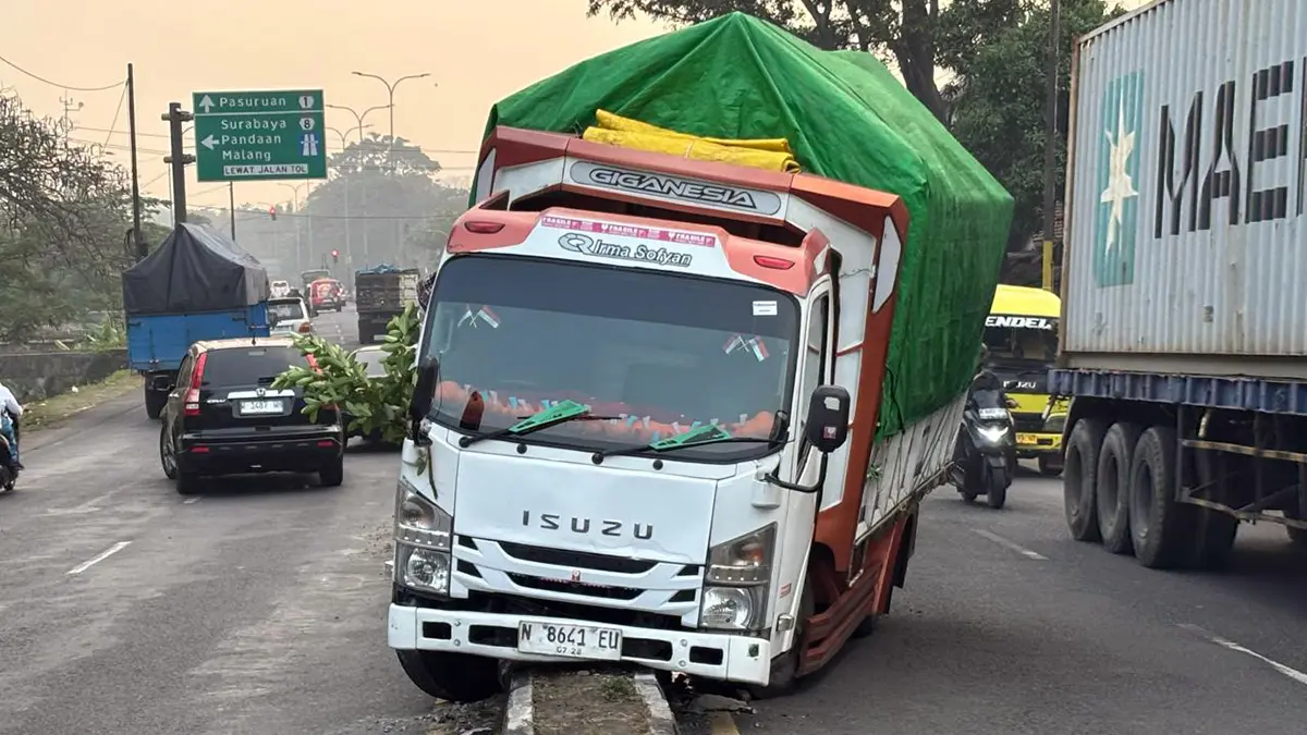 Kondisi truk yang hilang kendali dan nangkring di median jalan raya Surabaya-Malang, Desa/ Kecamatan Purwodadi, Kabupaten Pasuruan, Selasa (4/8). 