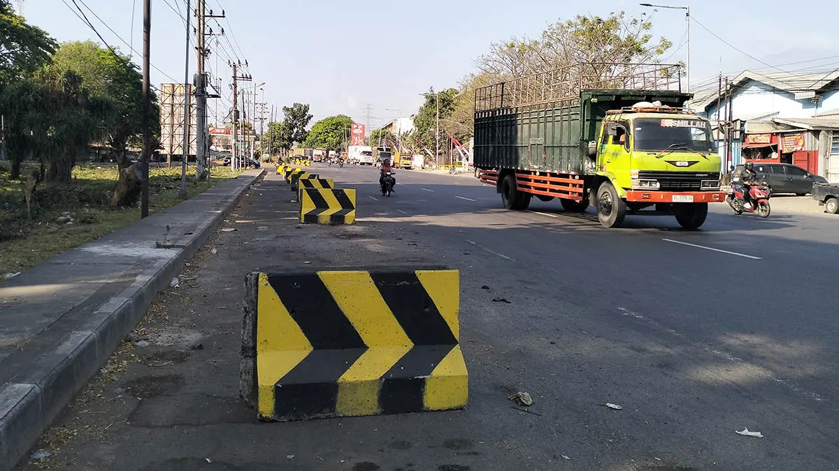 STERIL: Jajaran brigade beton yang dipasang oleh Dishub Kabupaten Pasuruan di Bundaran Apollo, Desa Karangrejo, Kecamatan Gempol. Pemasangan barikade fisik ini terbukti efektif membersihkan kawasan setempat dari parkir liar truk. (Rizal Syatori/Radar Bromo)