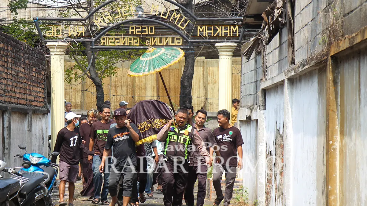 MENUJU PEMAKAMAN: Sejumlah warga bersama personel kepolisian mengantarkan jenazah Widi ke peristirahatan terakhir Selasa pagi (4/8). (Mokhamad Zubaidillah/ Radar Bromo)