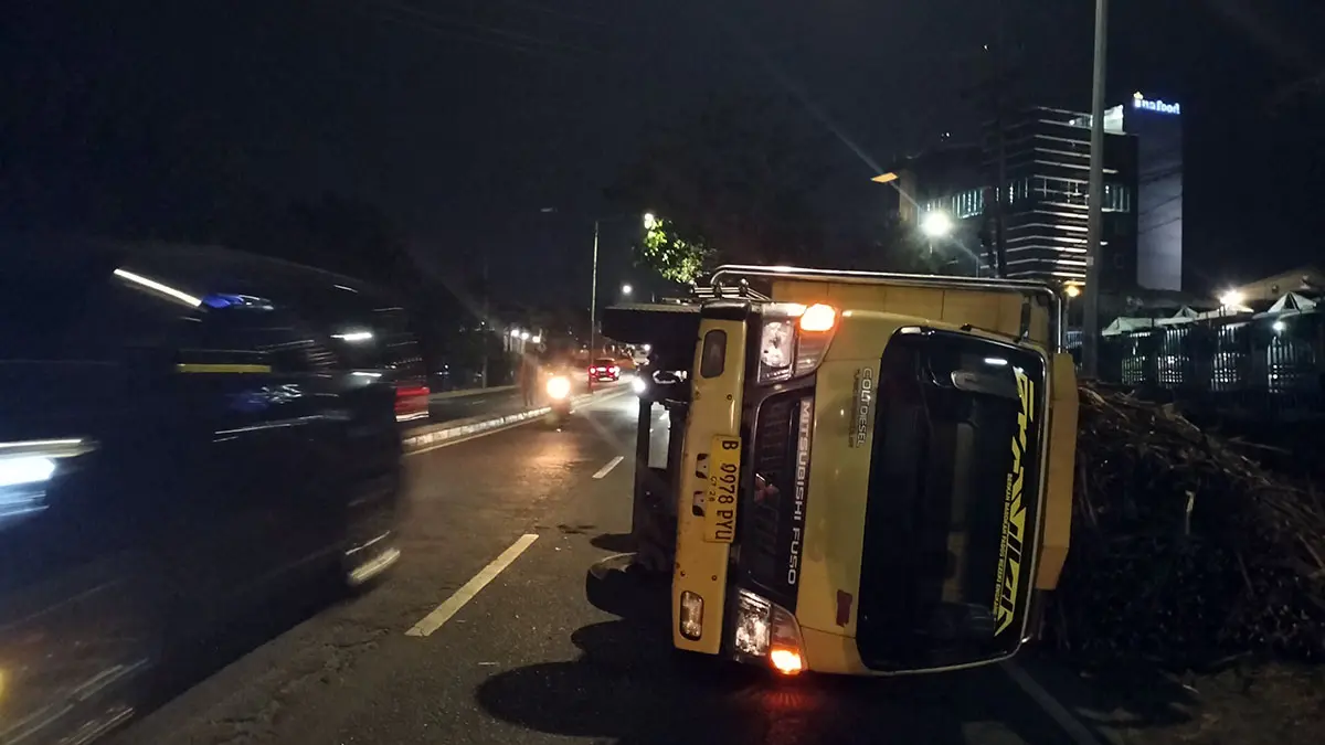 AMBRUK: Truk bernopol B 9978 PYU bermuatan tebu yang terguling di jalan nasional Malang–Surabaya, Desa Lemahbang, Kecamatan Sukorejo, Selasa malam (4/8). 