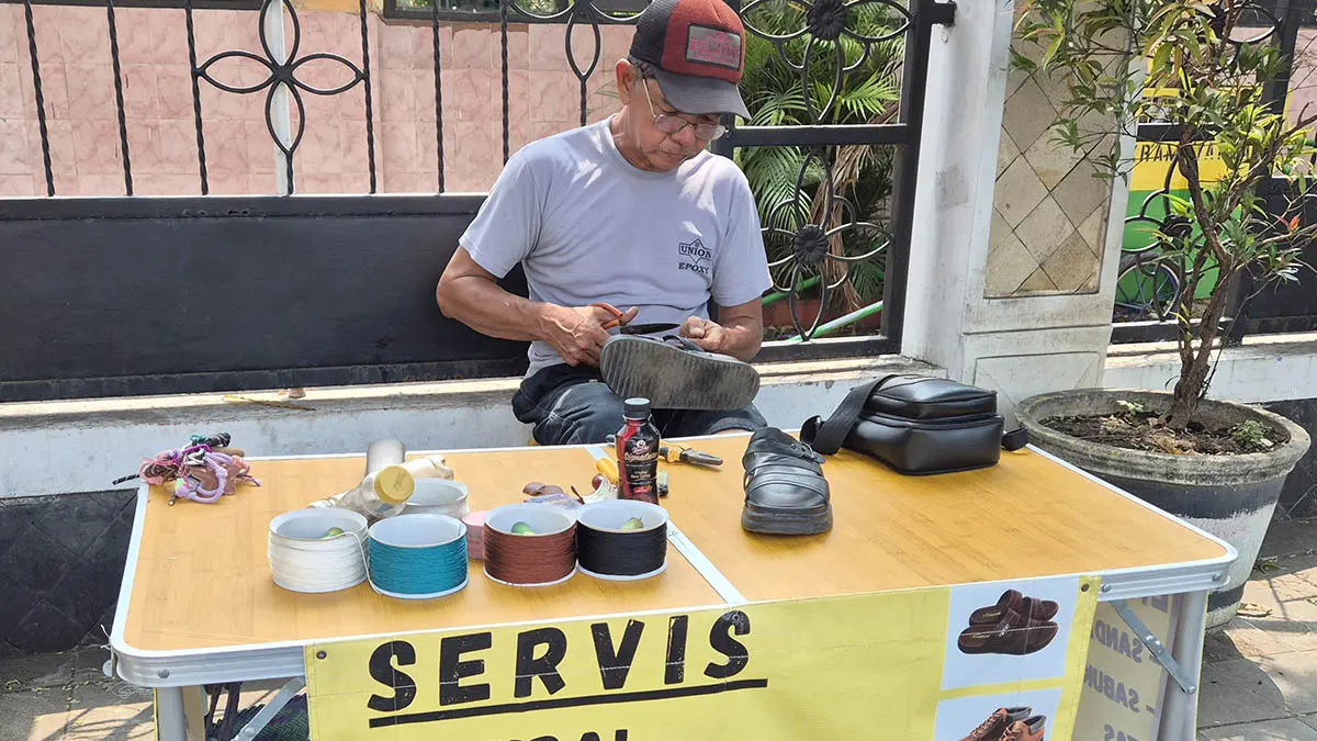 ENGGAN MENGANGGUR: Ahmad Jawahir di lapak servis sepatu miliknya di Jalan Pati Unus, Kota Pasuruan. (Foto: Fahrizal Firmani/Jawa Pos Radar Bromo)