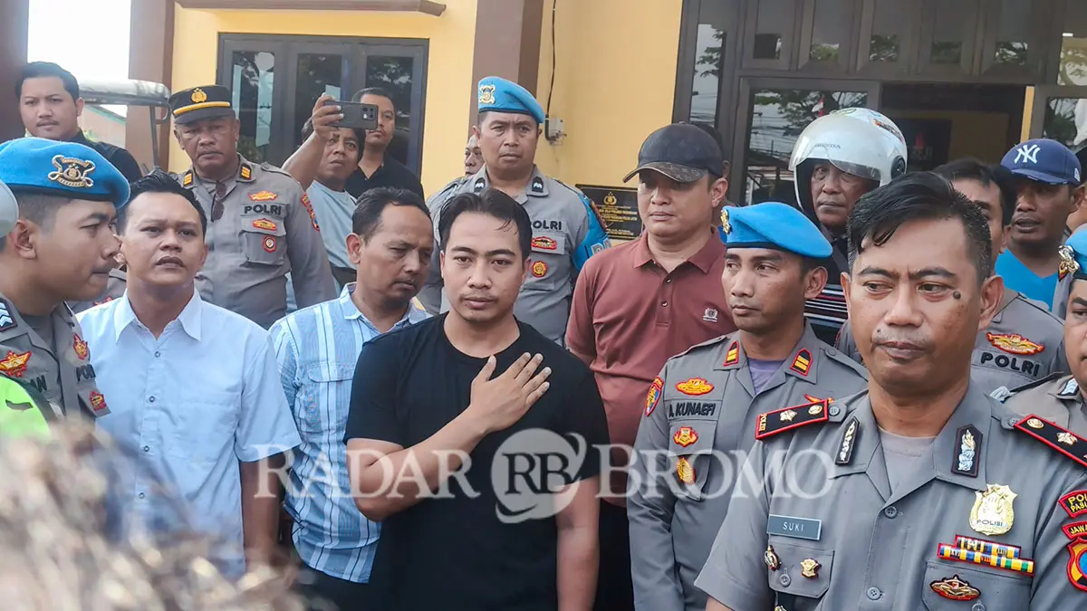 KINI DIPERIKSA: Briptu Dandum (kaus hitam) dan Kapolsek Beji Kompol Sukiyanto (depan, kanan) saat menemui warga yang nggeruduk Polsek Beji buntut kematian Widi, warga Gununggangsir sesaat usai ditangkap polisi. (Mokhamad Zubaidillah/ Radar Bromo)