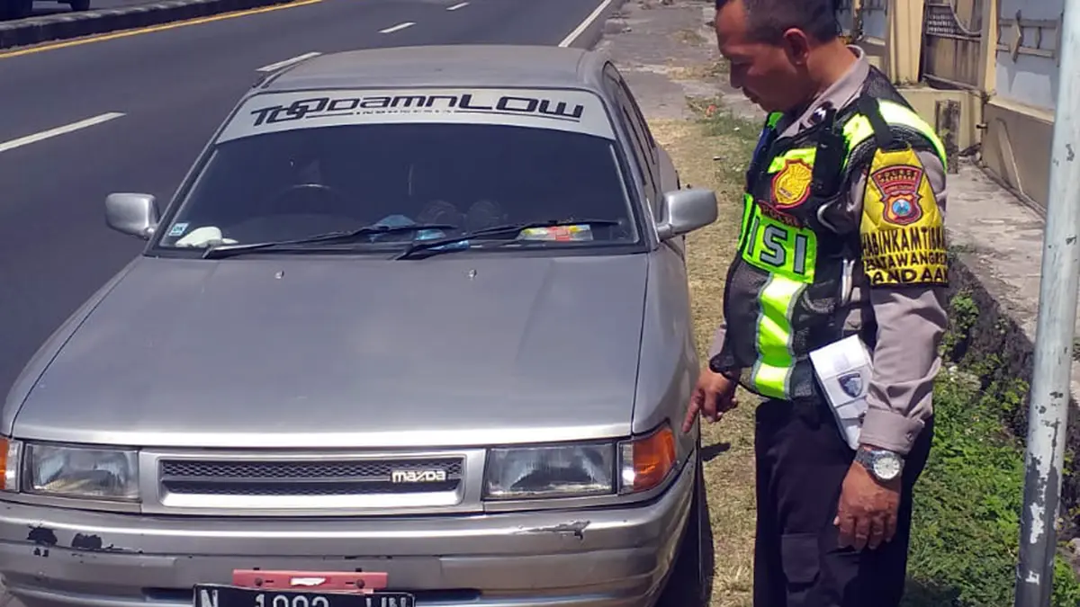 DIAMANKAN: Petugas mengamankan sedan Mazda yang ditinggal di tepi jalan raya Petungasri, Pandaan. (Istimewa)