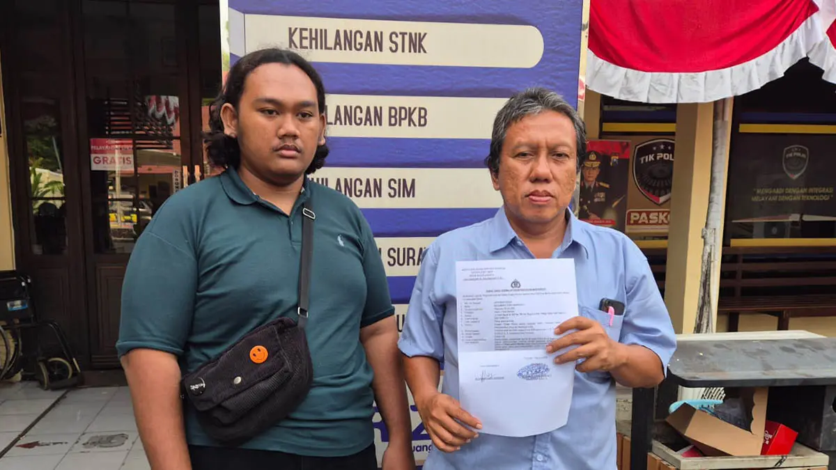 ADUAN: Wali asuh almarhumah Dewi Lestari, Januar Wahyudi, menunjukkan berkas saat resmi melaporkan manajemen RSUD dr. R. Soedarsono (RSUD Purut) ke Mapolres Pasuruan Kota. (Fahrizal Firmani/Radar Bromo)