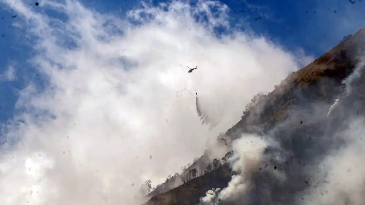 ANDALKAN WATER BOMBING: Helikopter BNPB saat berupaya memadamkan sabana Bromo yang terbakar, Minggu (9/8) dengan metode water bombing. (Mokhamad Zubaidillah/ Radar Bromo)