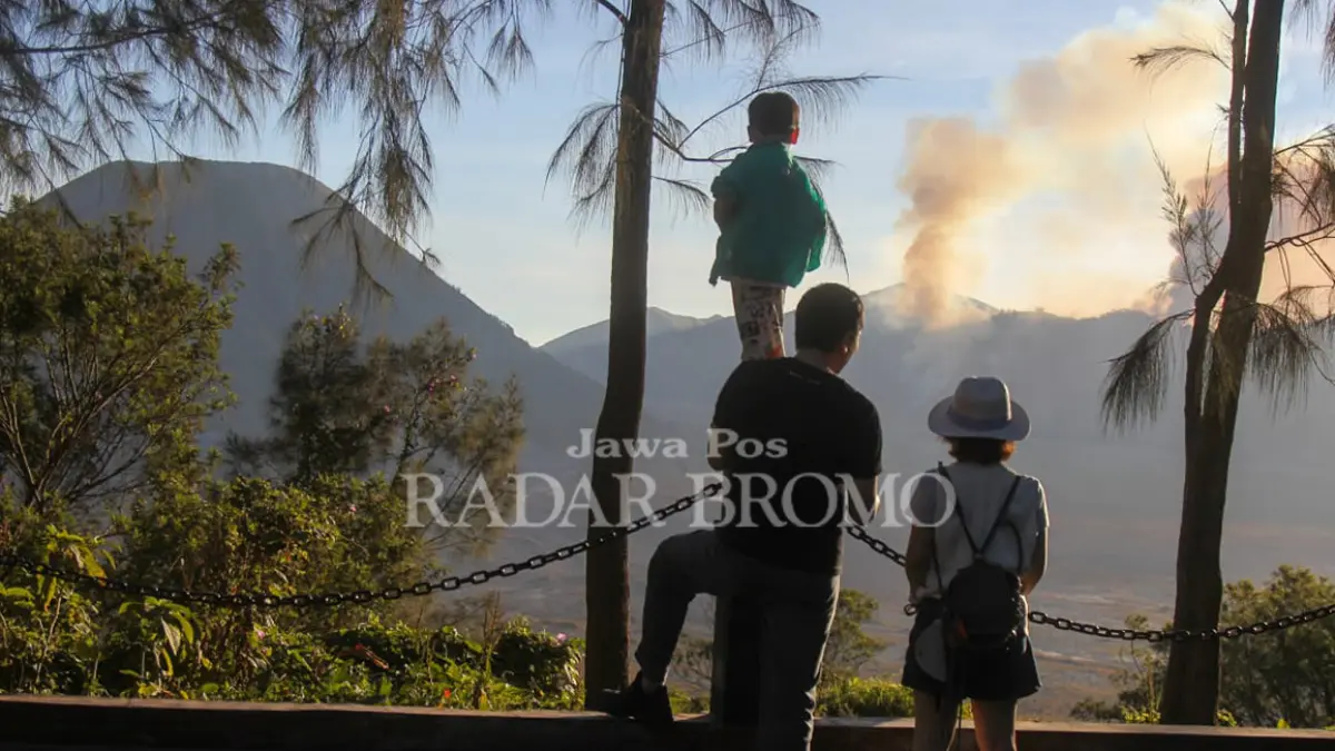 TAK BISA TURUN: Wisatawan asing mengamati kawasan Bukit Dingklik, Pasuruan yang terbakar, Minggu sore (9/8). Mereka tak bisa menikmati keindahan Bromo lebih dekat, lantaran kawasan wisata Bromo ditutup lantaran api masih berkobar di kawasan sabana. (Mokhamad Zubaidillah/ Radar Bromo)