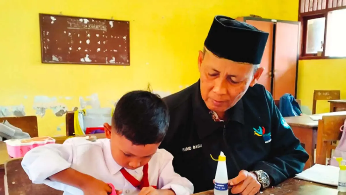 TELATEN : Wali Kelas I-II SDN Tanjung mendampingi satu-satunya siswa kelas I, Al Ghifari. (Achmad Arianto/Jawa Pos Radar Bromo)