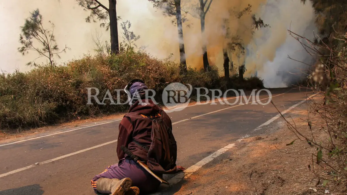 ISTIRAHAT SEJENAK: Salah satu petugas/ relawan istirahat sejenak usai kelelahan memadamkan api. (Mokhamad Zubaidillah/ Radar Bromo)