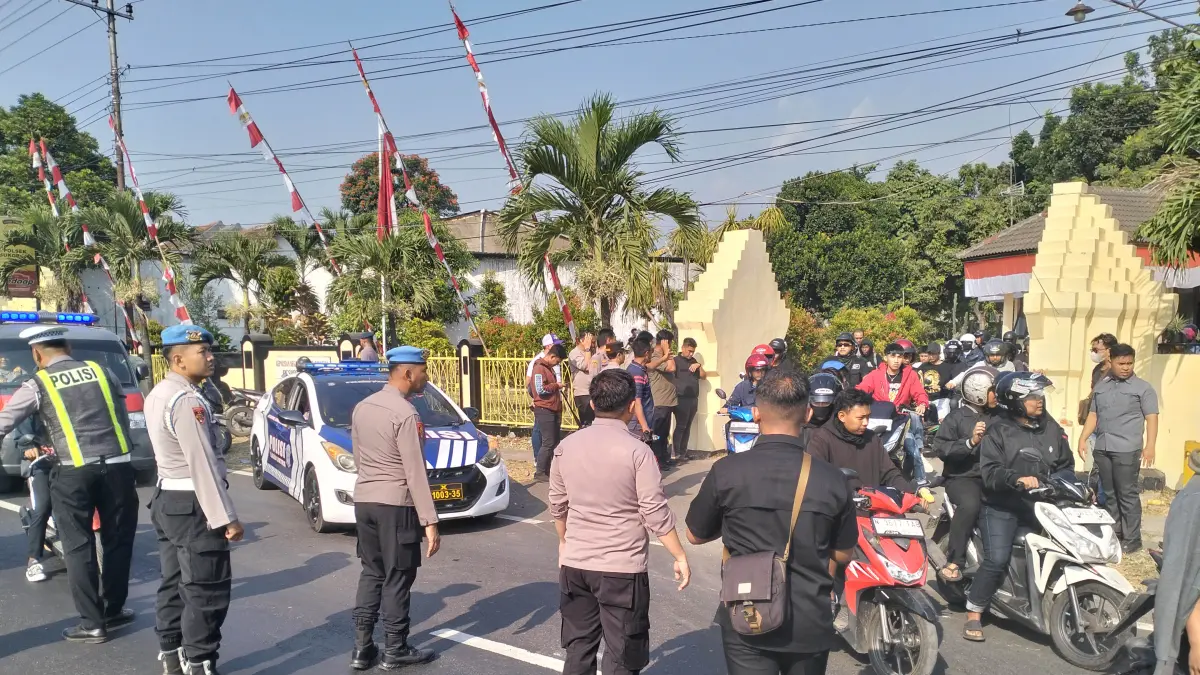 KETAR-KETIR_Rombongan suporter yang pulang dari konvoi di Malang keluar dari Mapolsek Sukorejo untuk melanjutkan perjalanan pulang dan dikawal petugas. (Foto: Rizal F Syatori/Jawa Pos Radar Bromo)