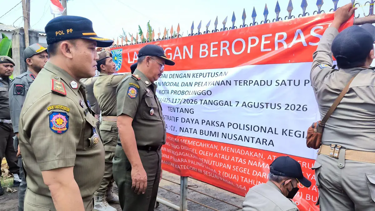 PASANG SEGEL: Petugas Satpol PP saat memasang segel di garasi truk yang terletak di pinggir jalan raya Lumajang, Kelurahan Kedung Asem, Kecamatan Wonoasih, Kota Probolinggo. 