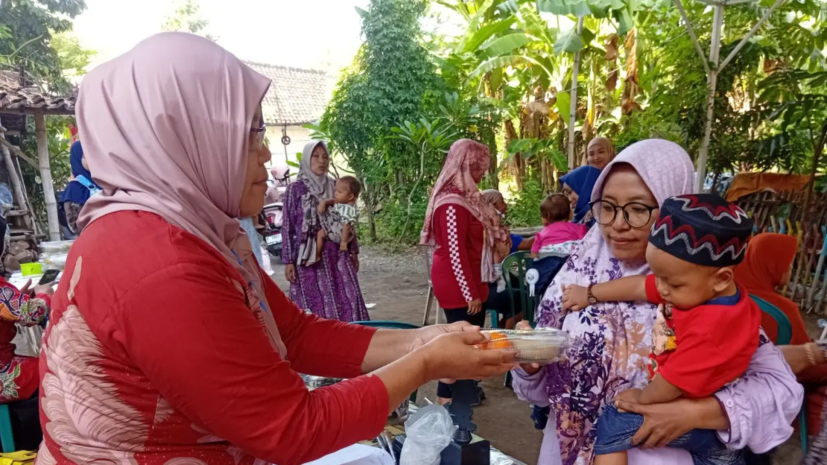 POSYANDU: Kader Posyandu Desa Tanjung Rejo memberikan PMT kepada balita usia mengikuti imunisasi. (Foto Pemdes Tanjung Rejo for Jawa Pos Radar Bromo)