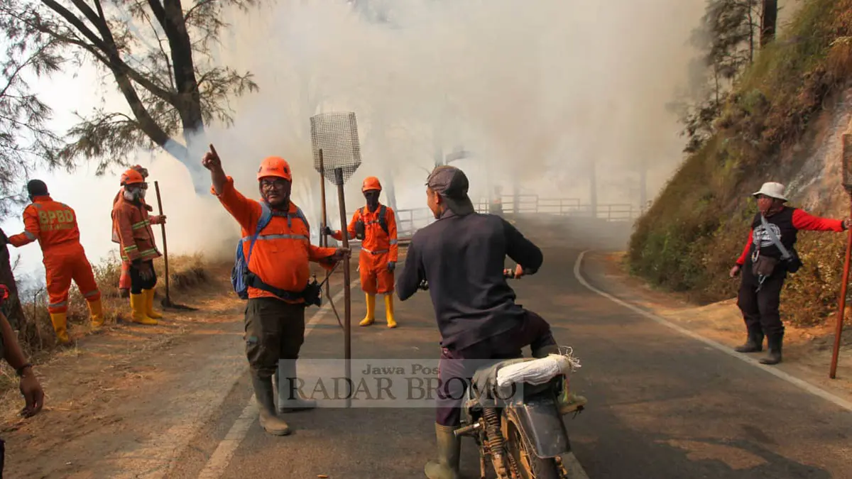 TAK BISA MASUK: Tak hanya memadamkan, petugas juga mencegat kendaraan yang melintas. Termasuk wisatawan yang hendak ke Bromo. (Foto: M Zubaidillah/Jawa Pos Radar Bromo)