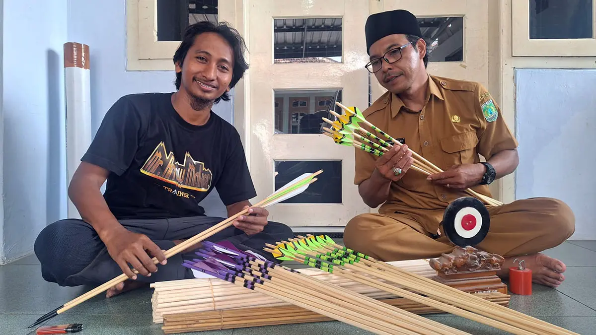 Ahmad Ifandi (kiri) menunjukkan anak panah buatannya yang dipasarkan hingga mancanegara. (M Busthomi/ Radar Bromo)
