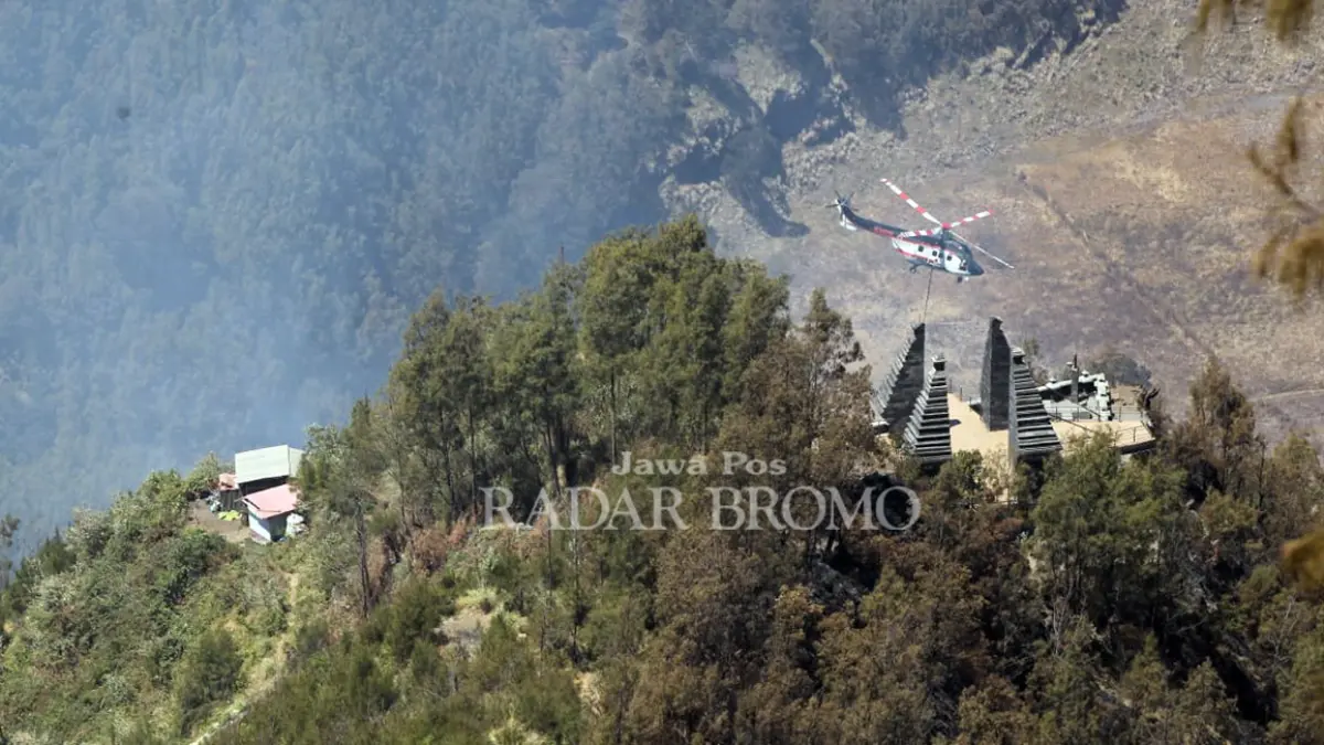 ASAP MULAI TERKENDALI: Sebuah heli saat melakukan water bombing di kawasan Seruni Point Bromo, Desa Ngadisari, Kecamatan Sukapura, Kabupaten Probolinggo. (Mokhamad Zubaidillah/ Radar Bromo)