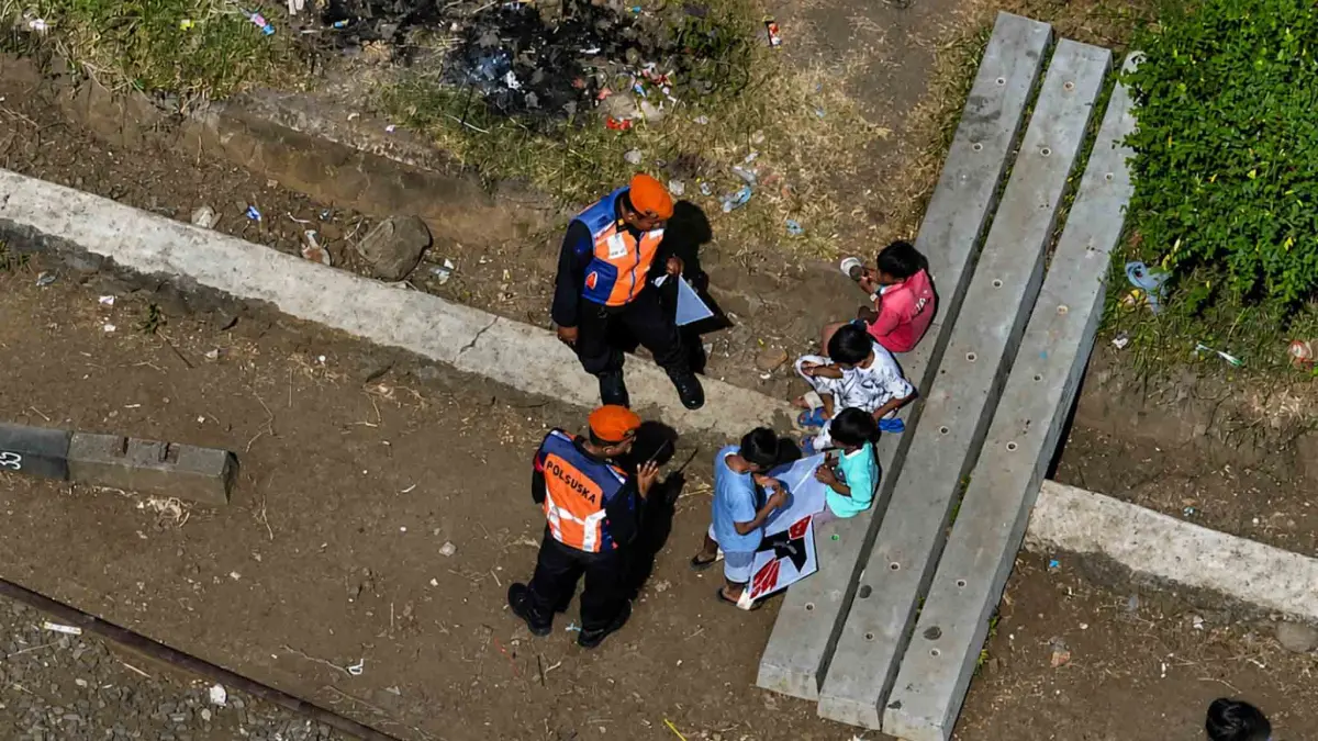 EDUKASI: Sejumlah petugas menghalau bocah yang berada di jalur KA. Mereka diingatkan untuk tidak bermain di sekitar jalur KA.&nbsp;(ISTIMEWA)
