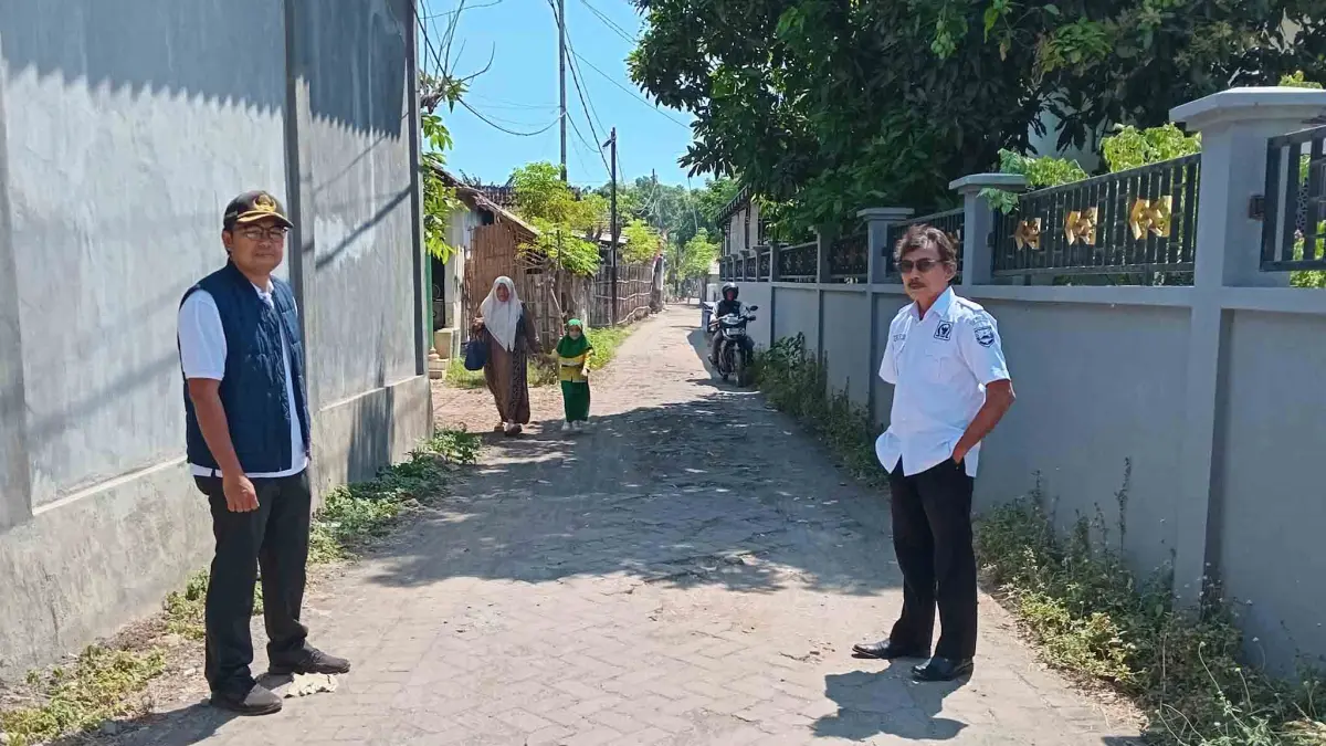 SIAP DIPAVING: Sekretaris Desa Rondokuning Moh. Su’udi (kiri) didampingi Kaur Keuangan Prasetiyo (pakai rompi) menunjukan jalan di Dusun Padukuhan yang akan dipaving.