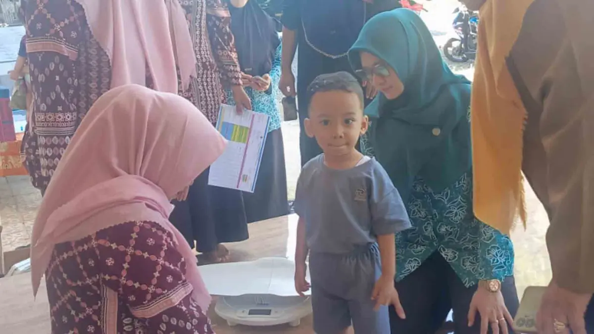 TIMBANG: Kader Posyandu Desa Rondokuning menimbang berat badan seorang balita dalam kegiatan Posyandu.