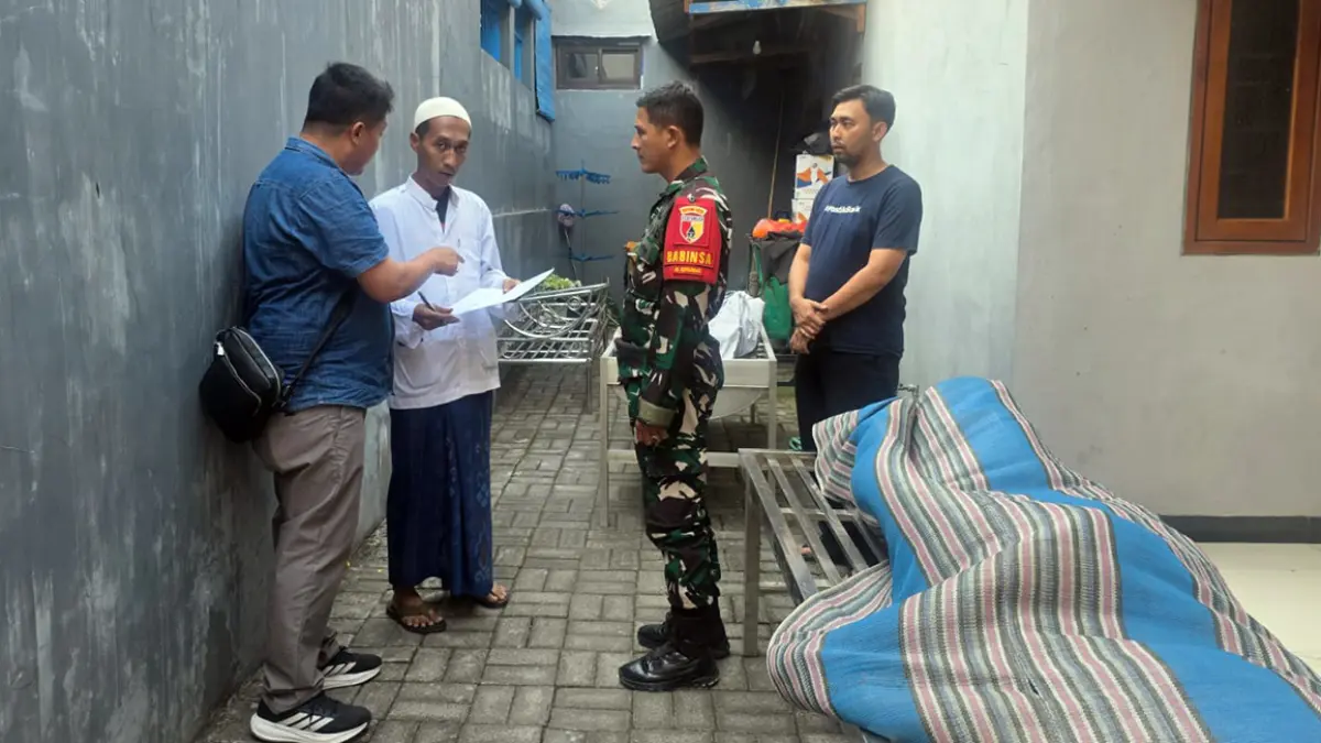 TOLAK OTOPSI: Petugas Polsek Gempol bersama Babinsa setempat memulangkan jenazah korban Handoko Aristiawa, 54, ke rumah duka. Keluarga menolak otopsi dan langsung memakamkan korban. 