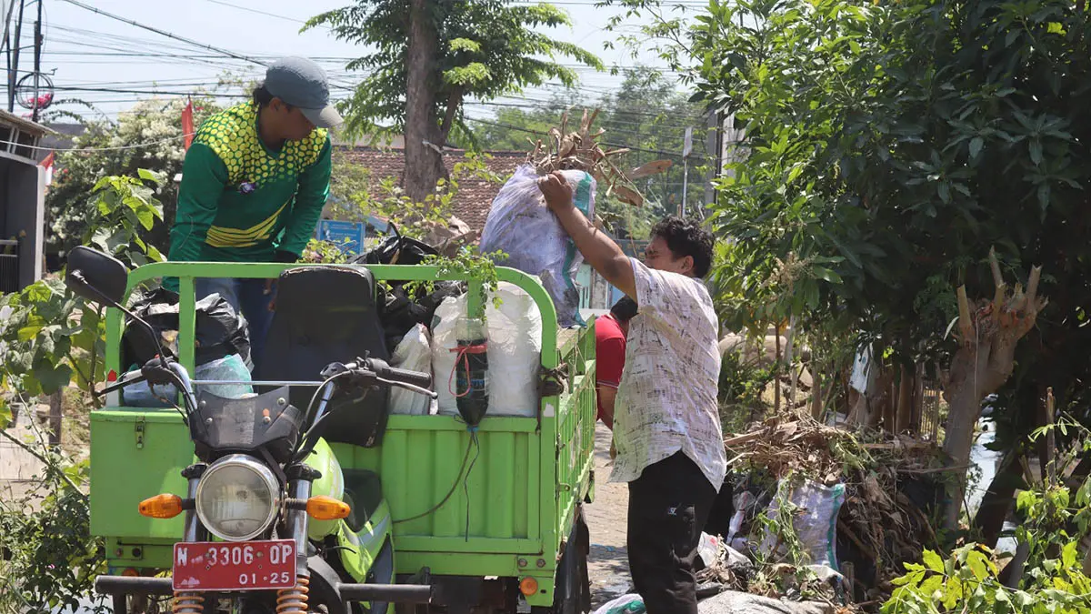 BANYAK: Proses pembersihan sampah di saluran irigasi wilayah Kecamatan Kraksaan beberapa waktu lalu. (Foto: Agus Faiz Musleh/Jawa Pos Radar Bromo)
