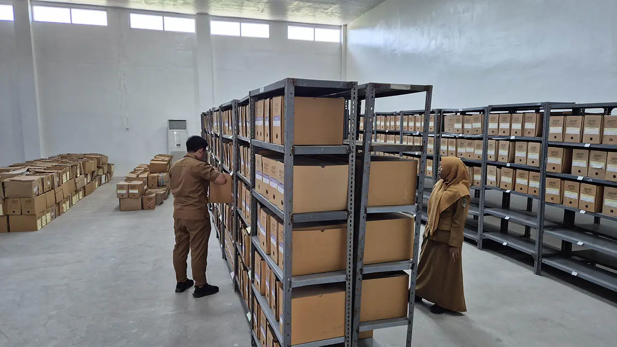 DIRAWAT: Petugas Dinas Perpustakaan dan Kearsipan (Disperpusip) Kota Pasuruan memeriksa dokumen di ruang penyimpanan Gedung Depo Arsip Kelurahan Sekargadung, Kecamatan Purworejo. (Fahrizal Firmani/Radar Bromo)