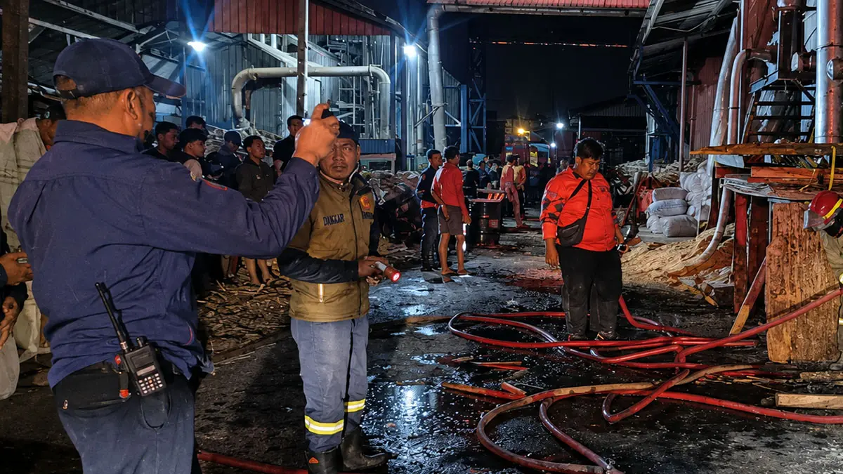 TERBAKAR: Tim Damkar Satpol PP Kota Probolinggo berusaha memadamkan api di cerobong serbuk kayu di salah satu pabrik pengolahan kayu di Kecamatan Kademangan, Kota Probolinggo, Sabtu (15/8) malam. (DAMKAR SATPOL PP KOTA PROBOLINGGO FOR FOR JAWA POS RADAR BROMO)